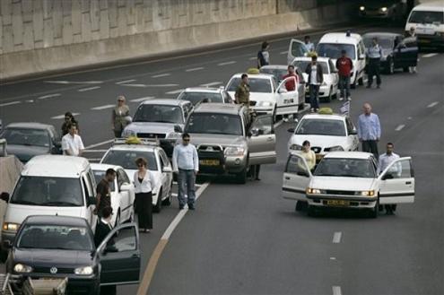 Israelis stand outside their cars as a siren marking the annual Holocaust remembrance day sounds in Tel Aviv, Israel, Monday, April 16, 2007. Sirens sounded across Israel on Monday morning, bringing life to a standstill as millions of Israelis observed a moment of silence to honor the memory of the victims of the Holocaust. (AP Photo/Ariel Schalit)